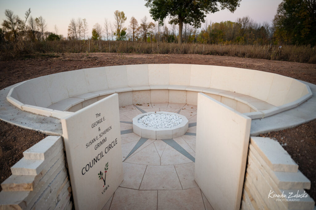 a stone seating area in the middle of a meadow with an inscribed entrance stone